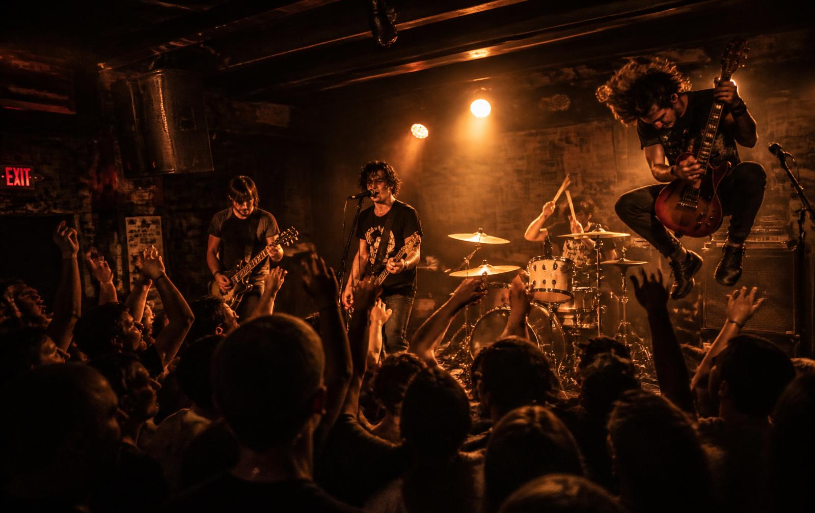 Rock band playing to a packed crowd in a small club